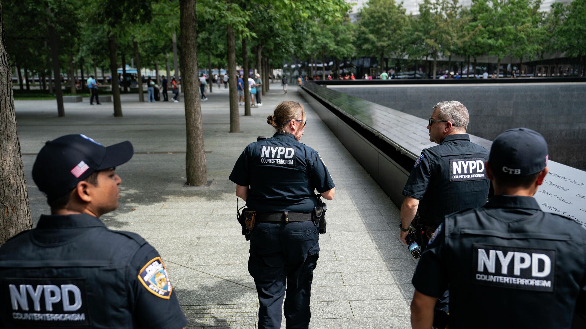 NYPD officer Michael Dougherty, a 25-year veteran, second from right, patrols with his colleagues beside the south reflecting pool of the 9/11 Memorial & Museum where names of his deceased colleagues and friends are displayed, Monday, Aug. 16, 2021, in New York.  - Sputnik International, 1920, 31.03.2023