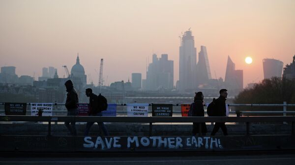 Commuters walk along Waterloo Bridge, which is being blocked by climate change activists, during the Extinction Rebellion protest in London, Britain April 17, 2019 - Sputnik International