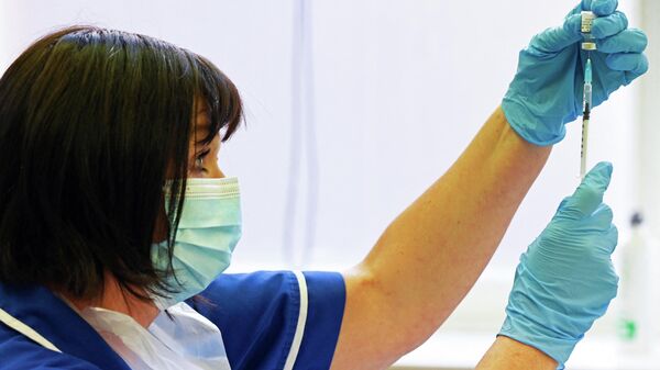 A nurse prepares a dose the Pfizer-BioNtech vaccine at a vaccination centre in Derby, central England on September 20, 2021 - Sputnik International