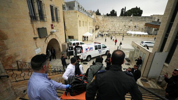 Israeli security personnel carry a dead body down the steps leading to the Western Wall following a shooting incident in Jerusalem's Old City November 21, 2021.  - Sputnik International