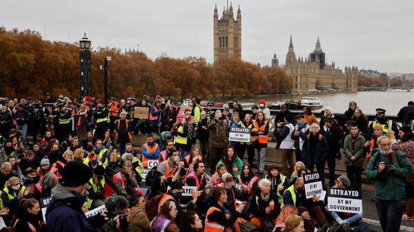 Climate change activists block traffic during a protest action in solidarity with activists from the Insulate Britain group who received prison terms for blocking roads, on Lambeth Bridge in central London on November 20, 2021.  - Sputnik International