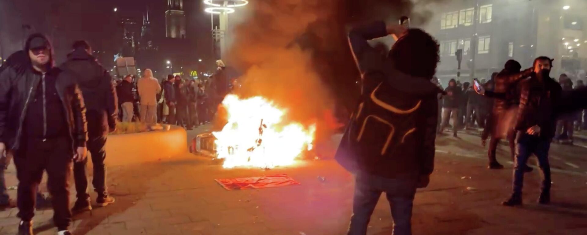 Protesters watch a motorcycle burning in Rotterdam, Netherlands November 20, 2021, in this screen grab obtained from a social media video. Video recorded November 20, 2021 - Sputnik International, 1920, 22.11.2021