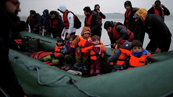 A group of more than 40 migrants with children get on an inflatable dinghy, as they leave the coast of northern France to cross the English Channel, near Wimereux, France, November 24, 2021 - Sputnik International