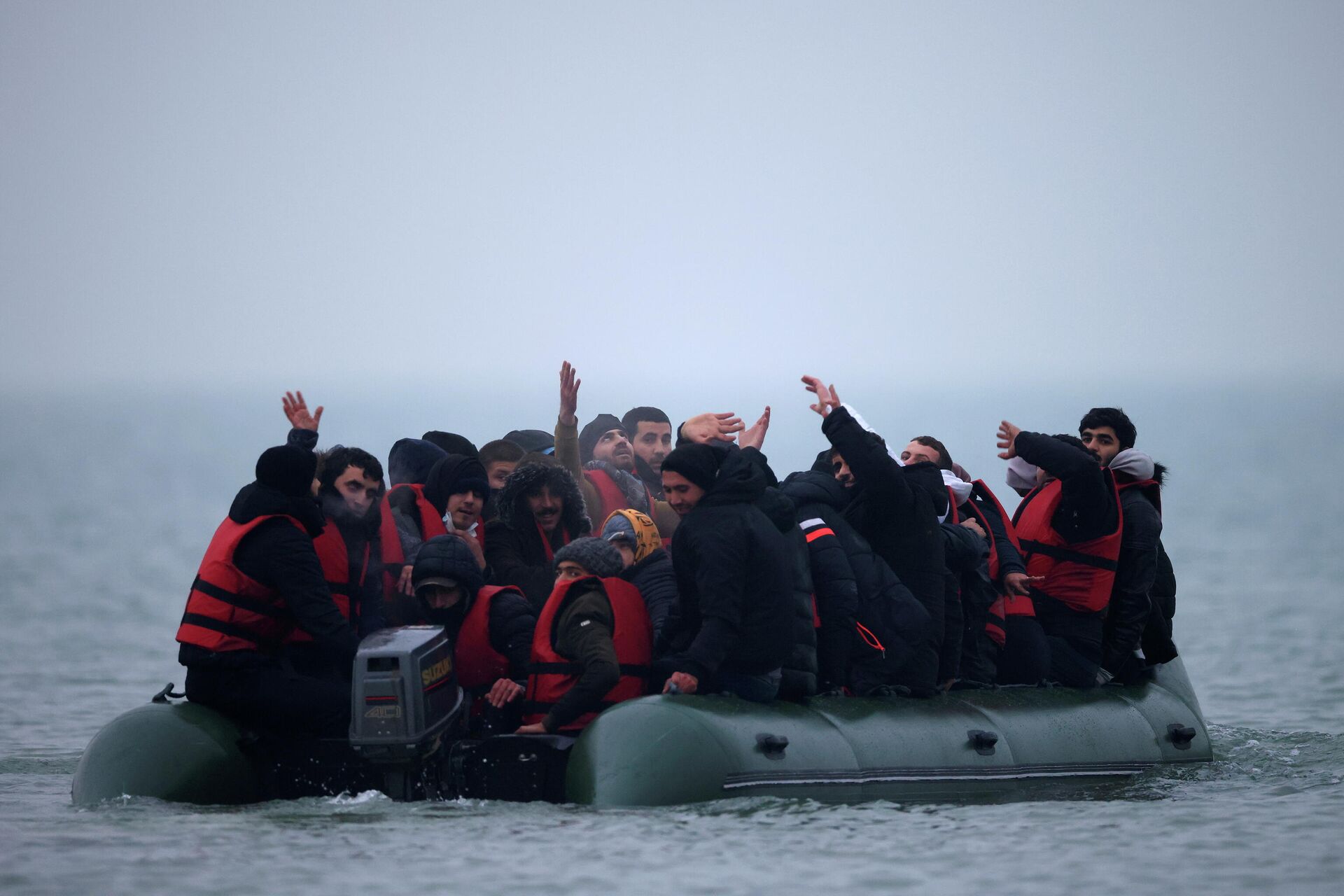 A group of more than 40 migrants react as they succeeded to get on an inflatable dinghy, to leave the coast of northern France and to cross the English Channel, near Wimereux, France, November 24, 2021. - Sputnik International, 1920, 25.11.2021