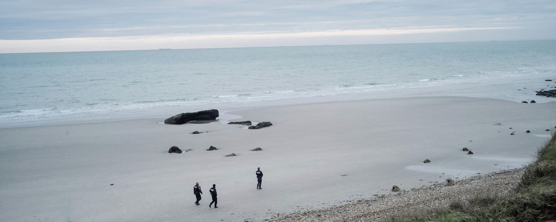 French police officers patrol on the beach in the searcher migrants in Wimereux, northern France, Wednesday, Nov.17, 2021. Several migrants died and others were injured Wednesday Nov.24, 2021 when their boat capsized off Calais in the English Channel as they tried to cross from France to Britain, authorities said. British and French authorities were searching the area using helicopters and coast guard vessels, according to the French maritime agency for the region. - Sputnik International, 1920, 13.11.2022
