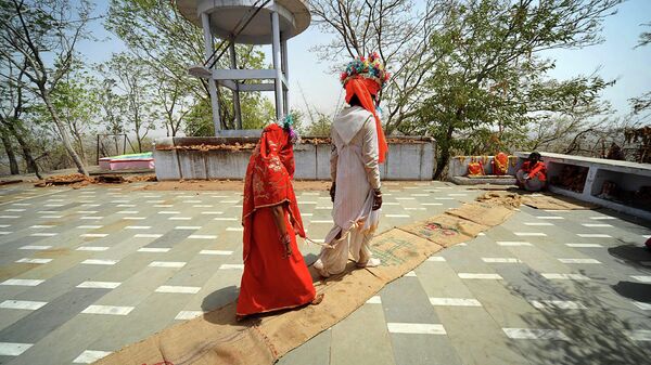 An under-age newly married couple who refused to be identified, walk to the temple to seek the blessings of a priest after a mass marriage at Chachoda village in Rajgarh town, about 155 kilometers (96 miles) from Bhopal, India, Sunday, May 16, 2010 - Sputnik International