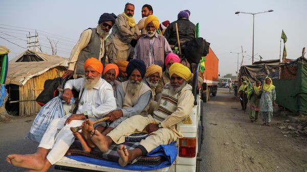 Farmers travel in a vehicle as they return back from Punjab state to attend the first anniversary of farmers' protests, on the outskirts of Delhi at Pakora Chowk near Tikri border, India, November 25, 2021 - Sputnik International