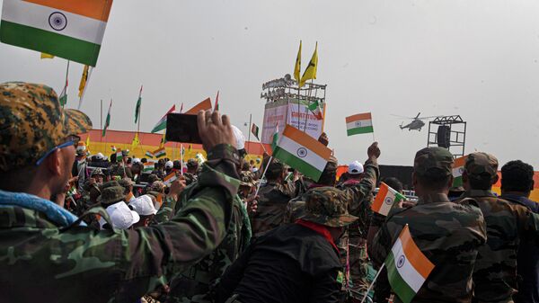 National Democratic Front of Bodoland (NDFB) cadres wave Indian flags as prime minister Narendra Modi arrives in a helicopter to attend an event to celebrate signing of a peace accord in Kokrajhar, a town 250 kilometers (150 miles) west of Gauhati, India, Friday, Feb. 7, 2020 - Sputnik International