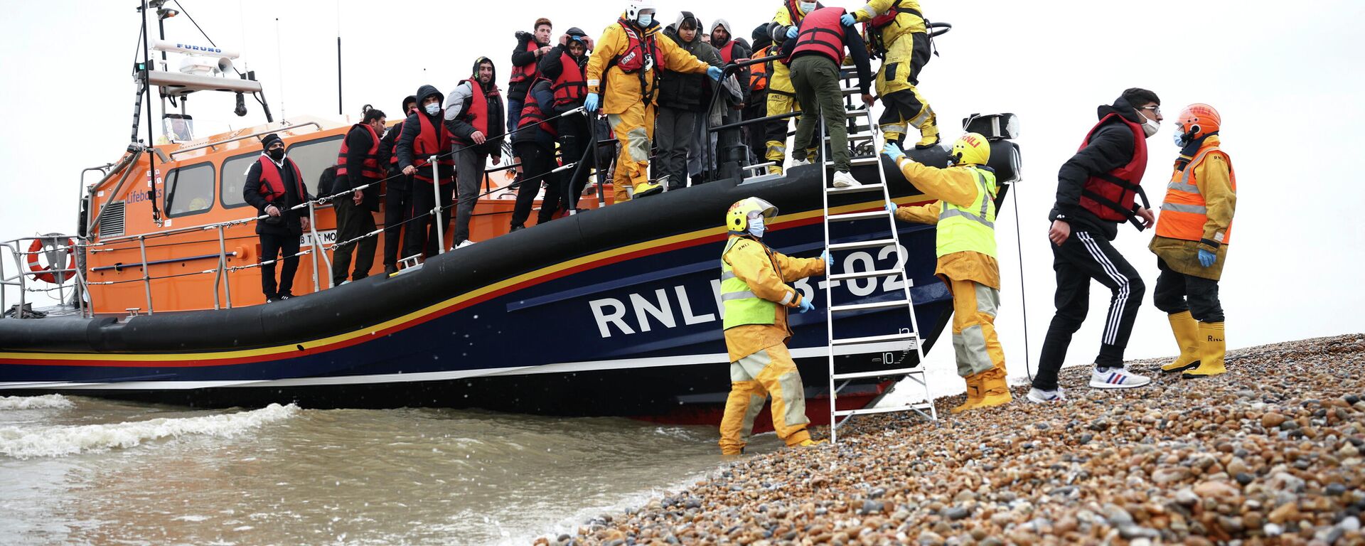 Migrants are brought ashore onboard a RNLI Lifeboat, after having crossed the channel, in Dungeness, Britain, November 24, 2021 - Sputnik International, 1920, 28.11.2021