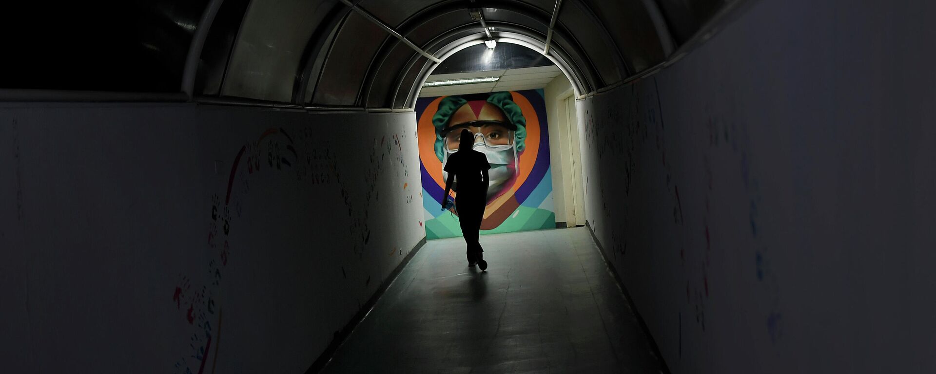 A health worker walks past a mural by the graffiti artist Badsura, at the Ana Francisca Perez de Leon II public Hospital in Caracas, Venezuela, Saturday, March 27, 2021 - Sputnik International, 1920, 29.11.2021