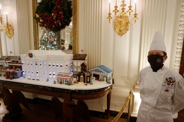 White House Pastry Chef Susan Morrison stands with the official 2021 Gingerbread White House, made from 120 pounds (54 kg) of hard-drying modelling paste (pastillage), to honour front-line workers including first responders, grocery workers and post service staff, during a press tour of the White House Christmas decorations ahead of holiday receptions by US President Joe Biden and first lady Jill in Washington, DC, 29 November 2021. - Sputnik International
