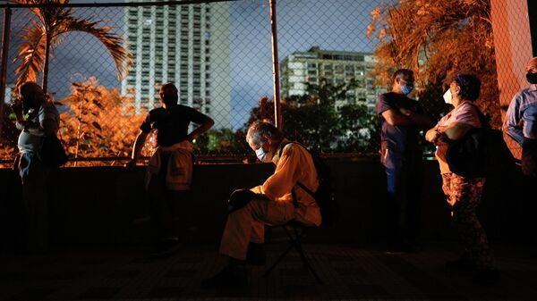 Residents wait outside a vaccination center in hopes of getting a second dose of the Sputnik V COVID-19 vaccine, as the sun begins to rise in Caracas, Venezuela, Friday, Sept. 17, 2021. - Sputnik International