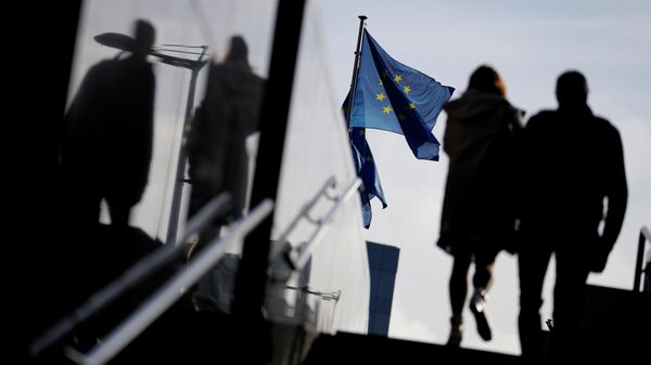 A couple walk past EU flags outside EU headquarters in Brussels, Tuesday, Oct. 26, 2021 - Sputnik International