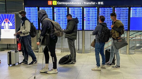 Transit passengers wait in line upon their arrival at Paris Charles de Gaulle airport Tuesday Dec. 22, 2020 - Sputnik International