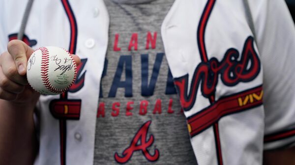 Nov 2, 2021; Houston, TX, USA; A fan of the Atlanta Braves holds up an autographed baseball before game six of the 2021 World Series between the Houston Astros and the Atlanta Braves at Minute Maid Park. - Sputnik International