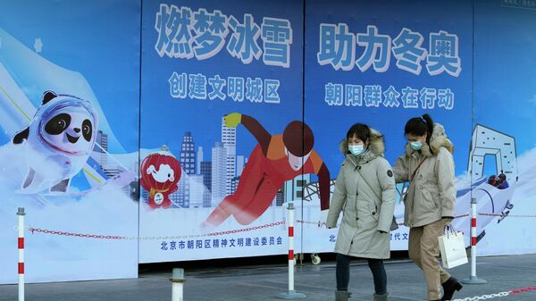 Residents wearing masks pass by propaganda boards promoting the upcoming Beijing Winter Olympics in Beijing, China, Monday, Nov. 22, 2021 - Sputnik International