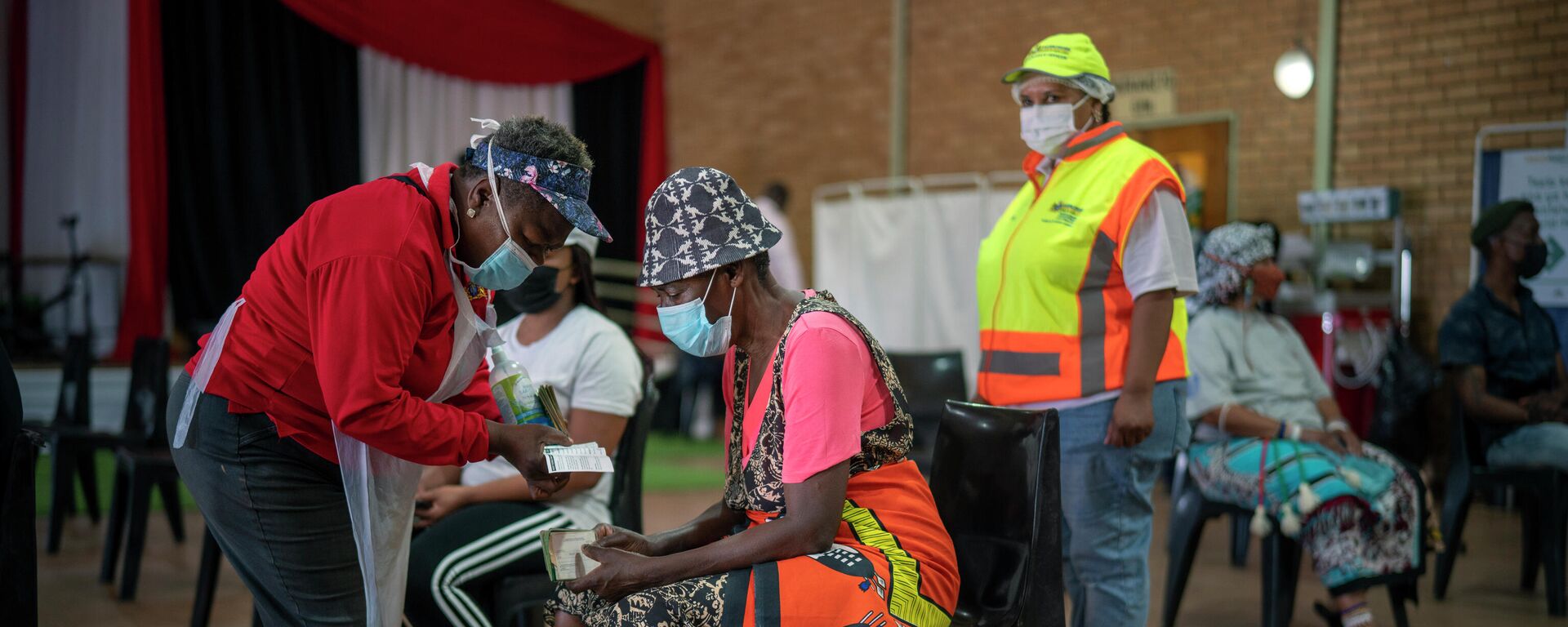 An Orange Farm, South Africa, resident listens to a nurse after receiving his jab against COVID-19 Friday Dec. 3, 2021 at the Orange Farm multipurpose center. South Africa has accelerated its vaccination campaign a week after the discovery of the omicron variant of the coronavirus - Sputnik International, 1920, 28.01.2022