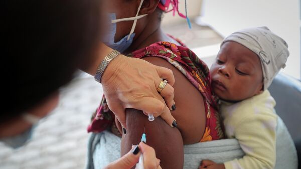 Healthcare worker administers the coronavirus disease (COVID-19) vaccine to a woman, in Johannesburg - Sputnik International