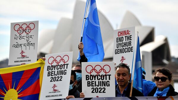 (FILES) In this file photo taken on June 23, 2021 protesters hold up placards and banners as they attend a demonstration in Sydney to call on the Australian government to boycott the 2022 Beijing Winter Olympics over China's human rights record. - Sputnik International