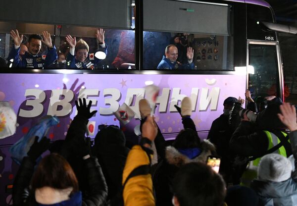 Members of the 20th expedition to the ISS, Russian cosmonaut Alexander Misurkin and two Japanese space tourists, Yusaku Maezawa and Yozo Hirano, wave goodbye from a bus at the Baikonur cosmodrome.  - Sputnik International