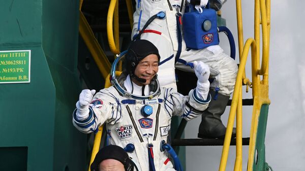 Roscosmos cosmonaut Alexander Misurkin (first from below) and space tourists, Japanese entrepreneur Yusaku Maezawa and his production assistant Yozo Hirano, wave to well-wishers before the launch of the Soyuz-2.1 rocket with the Soyuz MS-20 spacecraft to the International Space Station.  - Sputnik International