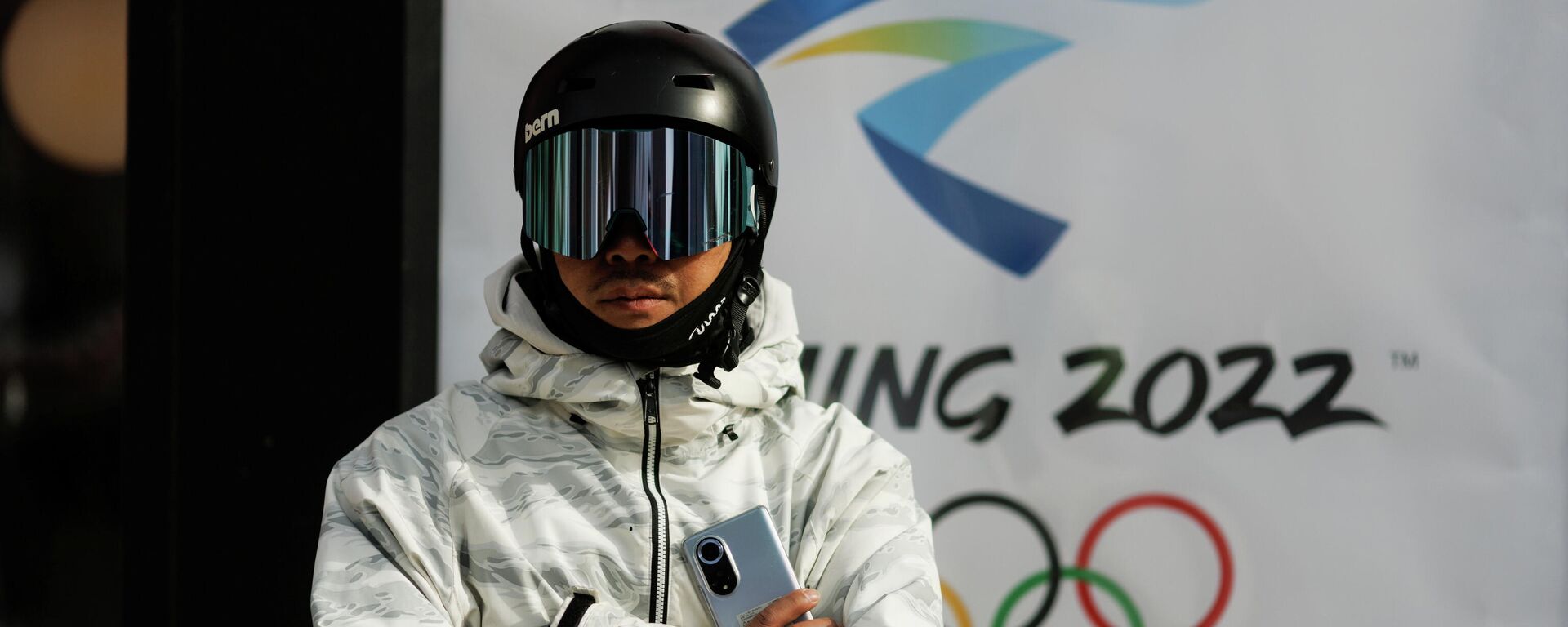 A snowboarder stands in front of the logo of the Beijing 2022 Winter Olympics in Zhangjiakou, Hebei province, China, November 20, 2021 - Sputnik International, 1920, 08.12.2021