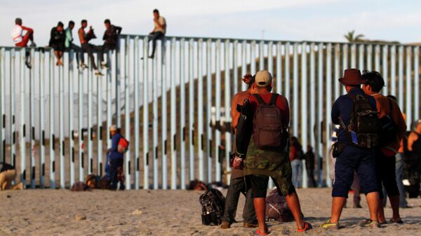 Migrants, part of a caravan of thousands trying to reach the U.S., gather at the border fence between Mexico and the United States after arriving in Tijuana, Mexico November 13, 2018 - Sputnik International