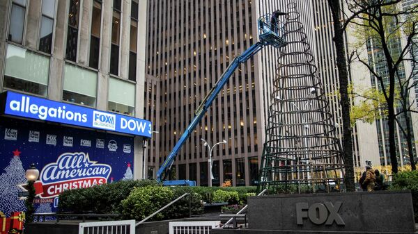 Workers clean up the burnt remains of a Christmas tree outside the News Corp. and Fox News building in New York City, New York, U.S. December 8, 2021 - Sputnik International
