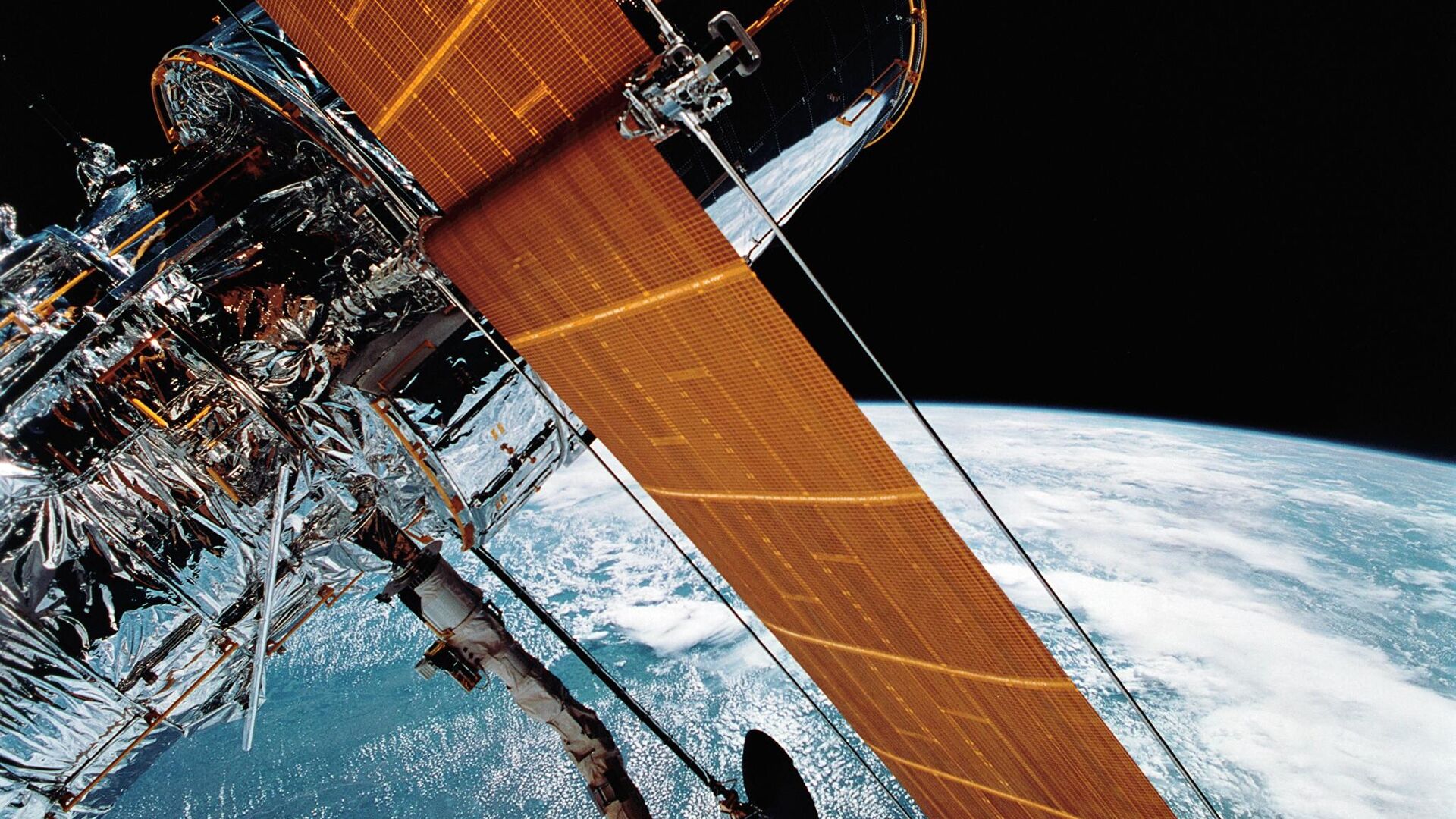 FILE - In this April 25, 1990 photograph provided by NASA, most of the giant Hubble Space Telescope can be seen as it is suspended in space by Discovery's Remote Manipulator System (RMS) following the deployment of part of its solar panels and antennae.   The Hubble Space Telescope should be back in action soon, Friday, July 16, 2021, following a tricky, remote repair job by NASA - Sputnik International, 1920, 24.02.2022