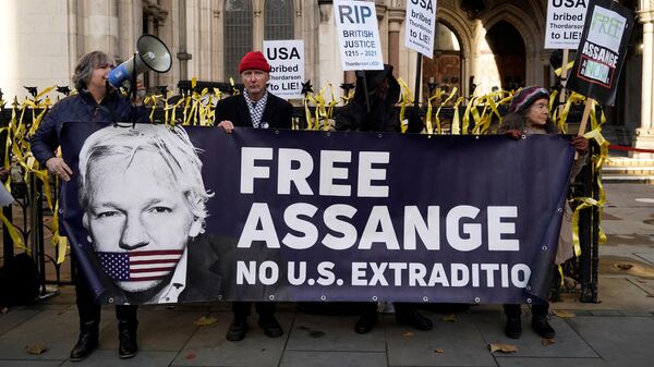 Supporters of WikiLeaks founder Julian Assange, hold placards outside the Royal Courts of Justice in London on December 10, 2021. - Sputnik International