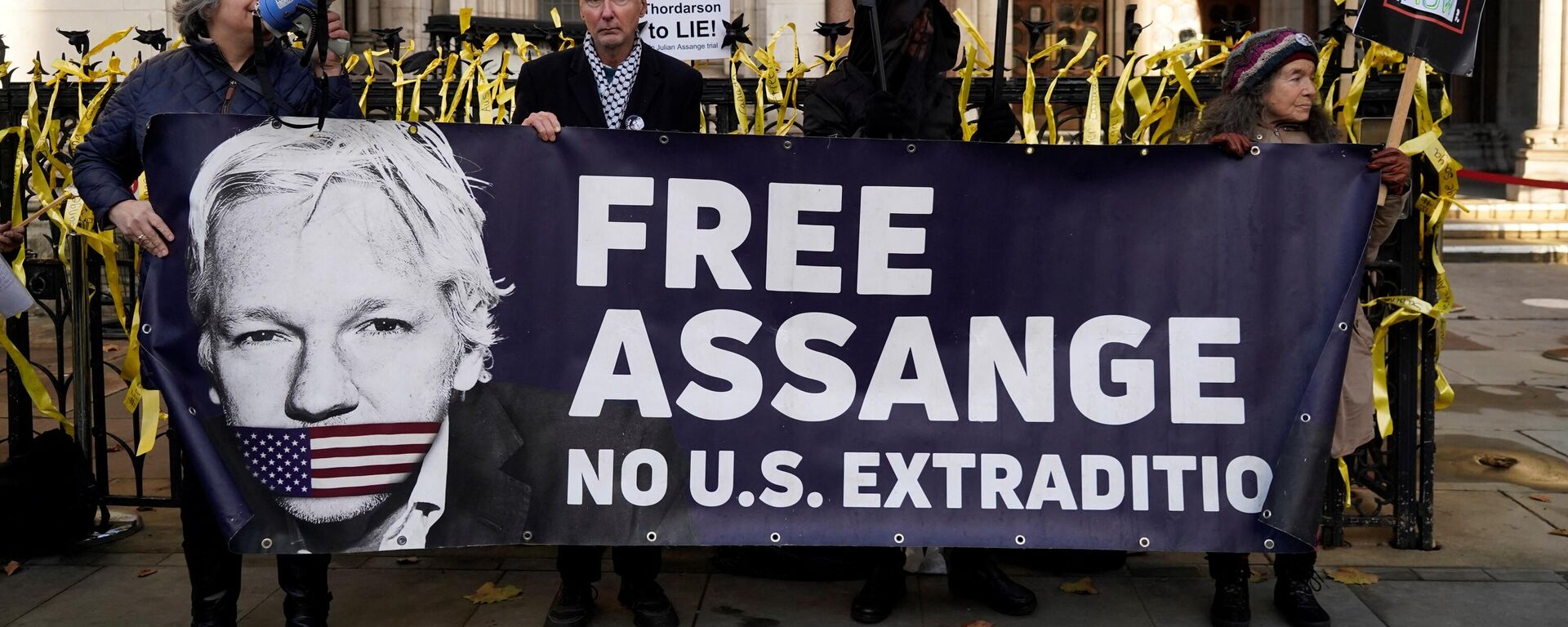 Supporters of WikiLeaks founder Julian Assange, hold placards outside the Royal Courts of Justice in London on December 10, 2021. - Sputnik International, 1920, 23.05.2024