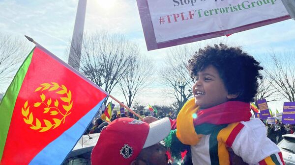 A boy holds an Eritrean flag in front of the Washington Monument during a #NoMore rally in Washington, DC, on December 10, 2021. Ethiopians and Eritreans have rallied for weeks against US intervention in their struggle against the Tigrayan People's Liberation Front (TPLF) rebel group. - Sputnik International