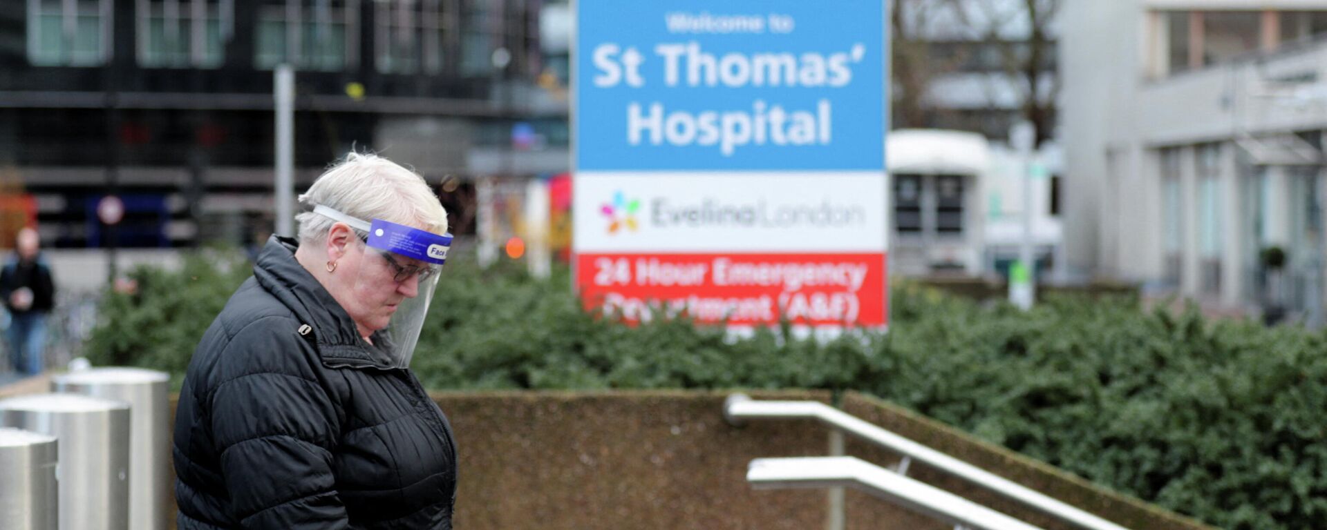 A person wearing personal protective equipment (PPE) walks outside St Thomas' Hospital as the spread of the coronavirus disease (COVID-19) continues, in London, Britain, December 12, 2021. - Sputnik International, 1920, 13.12.2021