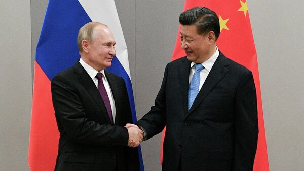 FILE PHOTO: Russian President Vladimir Putin shakes hands with Chinese President Xi Jinping during their meeting on the sidelines of a BRICS summit, in Brasilia, Brazil, November 13, 2019 - Sputnik International