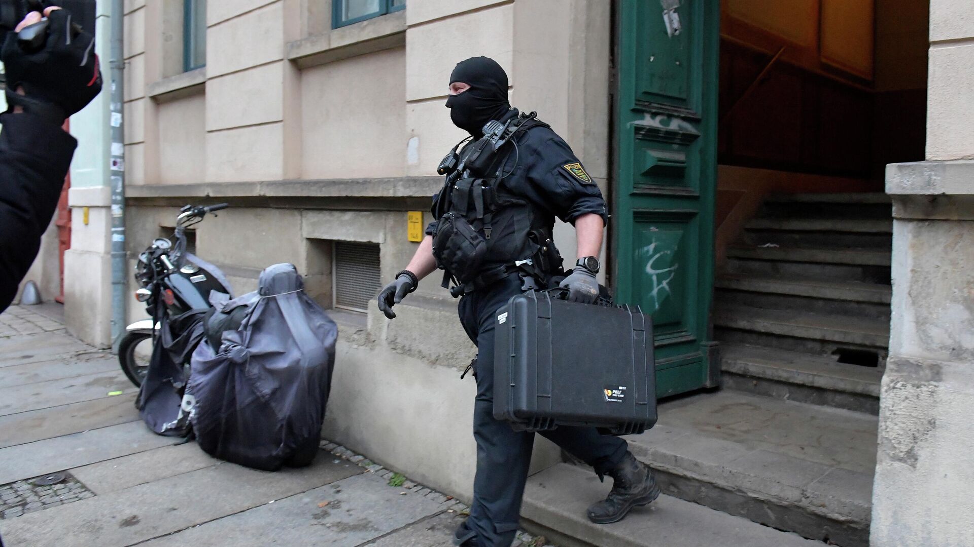 Police leaves a building during raids in several locations in Dresden, Germany, December 15, 2021, as part of an investigation into what they said was a plot to murder the state's prime minister, Michael Kretschmer, by anti-vaccination activists - Sputnik International, 1920, 15.12.2021