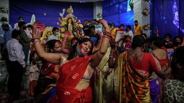 Devotees dance in rhythm in front of an idol of Hindu goddess Durga inside a pandal, a temporary structure set up to worship, during Durga Puja festival in New Delhi, India, Friday, Oct. 15, 2021 - Sputnik International