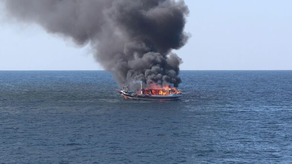 In this handout photograph from the U.S. Navy, a traditional dhow sailing vessel suspected of smuggling drugs burns in the Gulf of Oman on Wednesday, Dec. 15, 2021 - Sputnik International