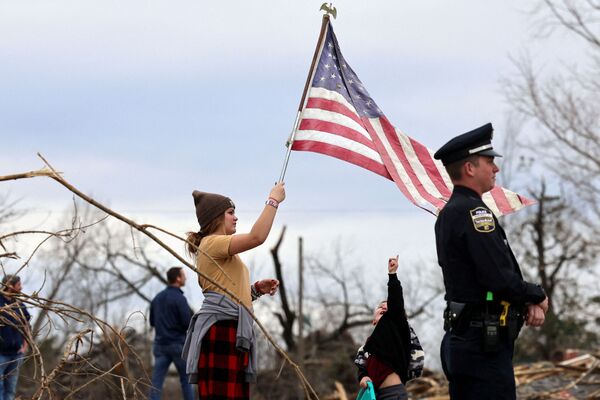 Raylie Hall holds a US flag as US President Joe Biden surveys storm damage from the tornadoes and extreme weather, in Dawson Springs, Kentucky, US, 15 December 2021. - Sputnik International