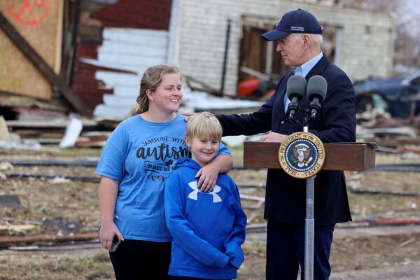 US President Joe Biden stands next to Dane Maddox, 7, in a neighbourhood devastated by an outbreak of tornadoes that passed through several states, in Dawson Springs, Kentucky, US, 15 December 2021. - Sputnik International