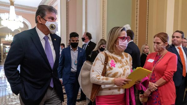 Sen. Joe Manchin, D-W.Va., left, walks with Sen. Kyrsten Sinema, D-Ariz., after attending a Democratic policy luncheon, Tuesday, Nov. 16, 2021, on Capitol Hill in Washington. - Sputnik International