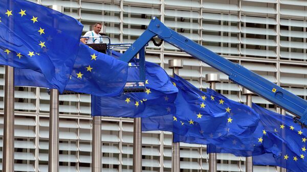 In this June 23, 2016 file photo, a worker on a lift adjusts the EU flags in front of EU headquarters in Brussels. - Sputnik International