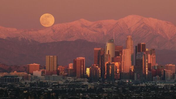 The full moon rises over snow covered mountains, behind the downtown Los Angeles skyline is seen from Kenneth Hahn State Recreation Area Tuesday, Dec. 29, 2020, in Los Angeles. - Sputnik International
