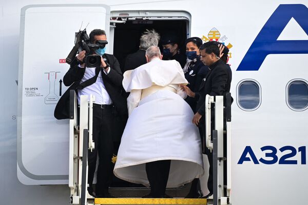A gust of wind blows the cassock of Pope Francis as he boards a plane at Athens International Airport in Greece, on 6 December 2021. - Sputnik International