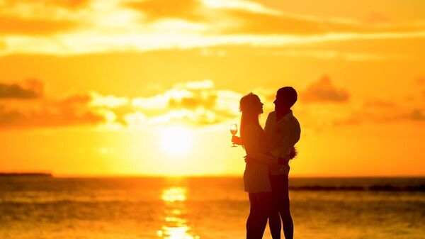 A couple on a beach at sunset - Sputnik International