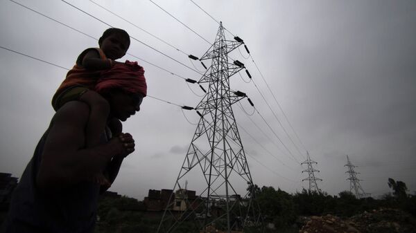 A man carries his son on his shoulders as he walks by electric towers in Jammu, India (File) - Sputnik International