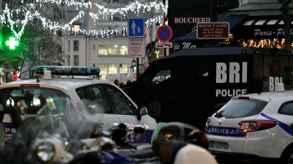 A van of the French Research and Intervention Brigade (BRI) police unit and police cars are seen at the entrance of the Aligre street, where A man armed with a knife, known for his psychiatric disorders, took two women hostage at an hardware shop in the 12th district of Paris, on December 20, 2021. - Sputnik International