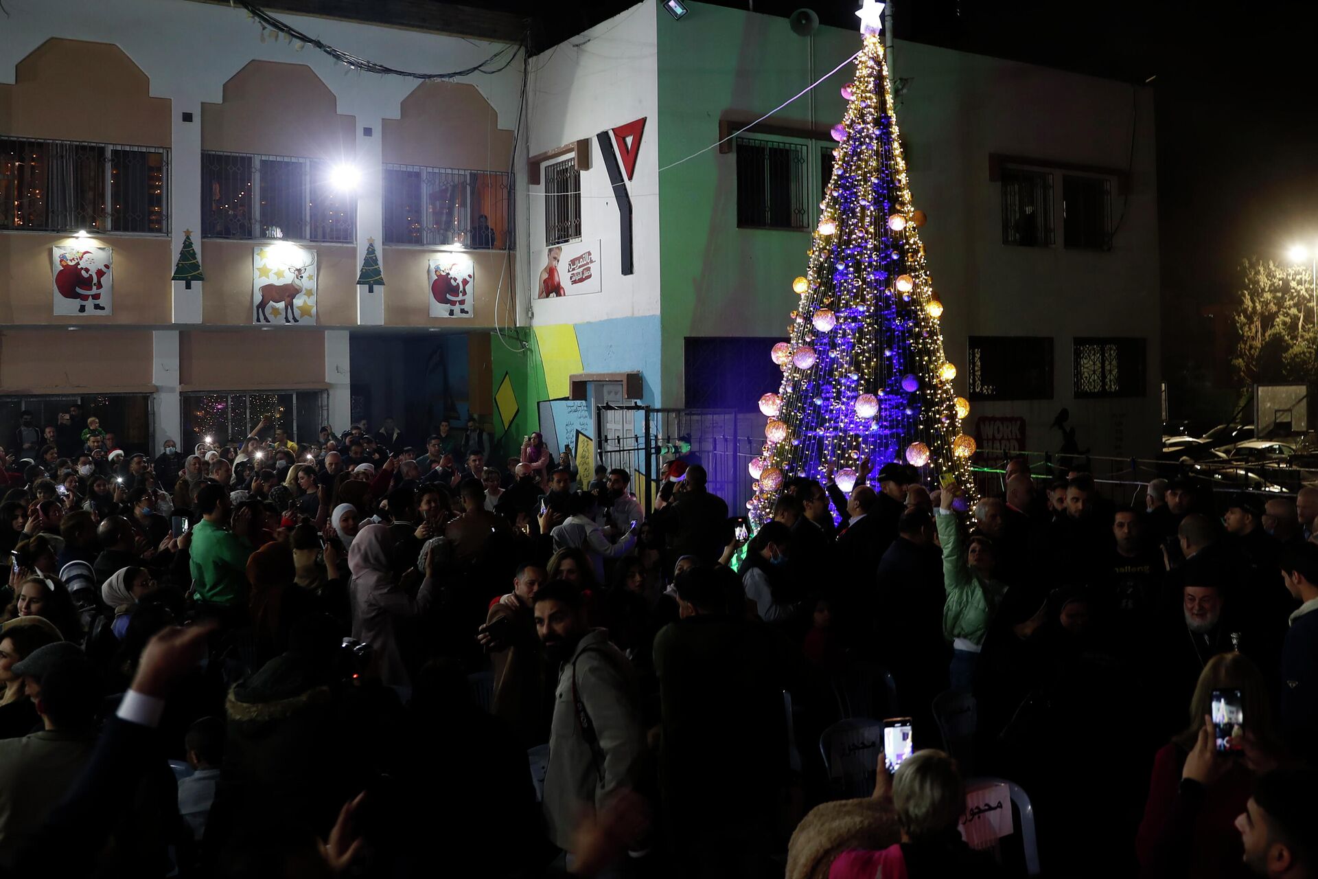 Palestinian Christians gather to take photos while celebrate lighting of the Christmas tree at the yard of Christian youth center in Gaza City, Friday, Dec. 10, 2021 - Sputnik International, 1920, 20.10.2023