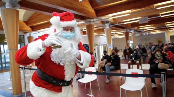 A man dressed as Santa Claus poses at the vaccination centre against the coronavirus disease (COVID-19) just before Christmas, in Brussels, Belgium, December 24, 2021 - Sputnik International