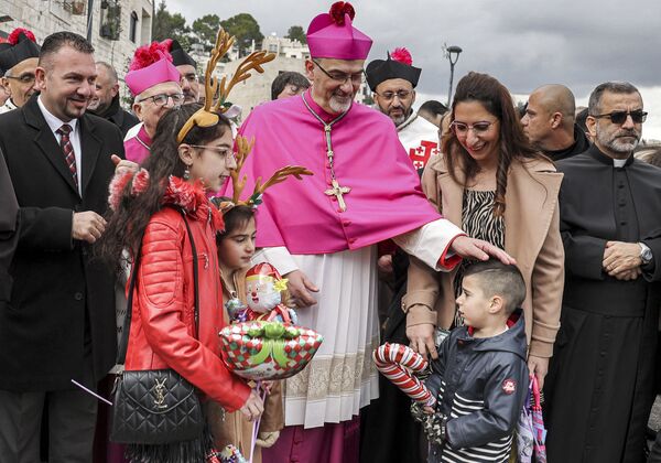 Pierbattista Pizzaballa (C), the Latin Patriarch of Jerusalem, greets children as he arrives at the Church of Nativity during Christmas celebrations in the biblical city of Bethlehem in the occupied West Bank on Christmas eve on 24 December 2021. - Sputnik International