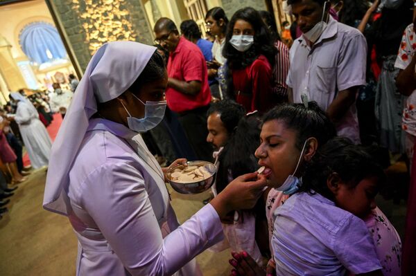 Christian devotees take communion during a Christmas mass at the Basilica of Our Lady of Lanka in Ragama on 25 December 2021.  - Sputnik International